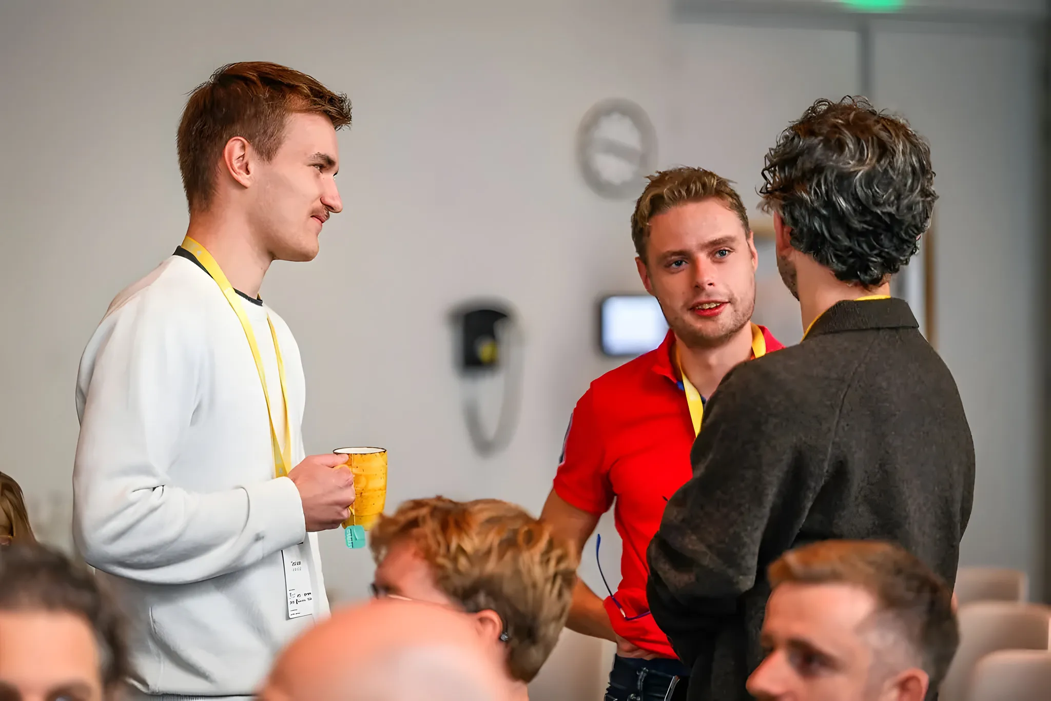 Timo Leser und Etiënne Korf im Gespräch mit einem Besucher zwischen den anderen Teilnehmenden.